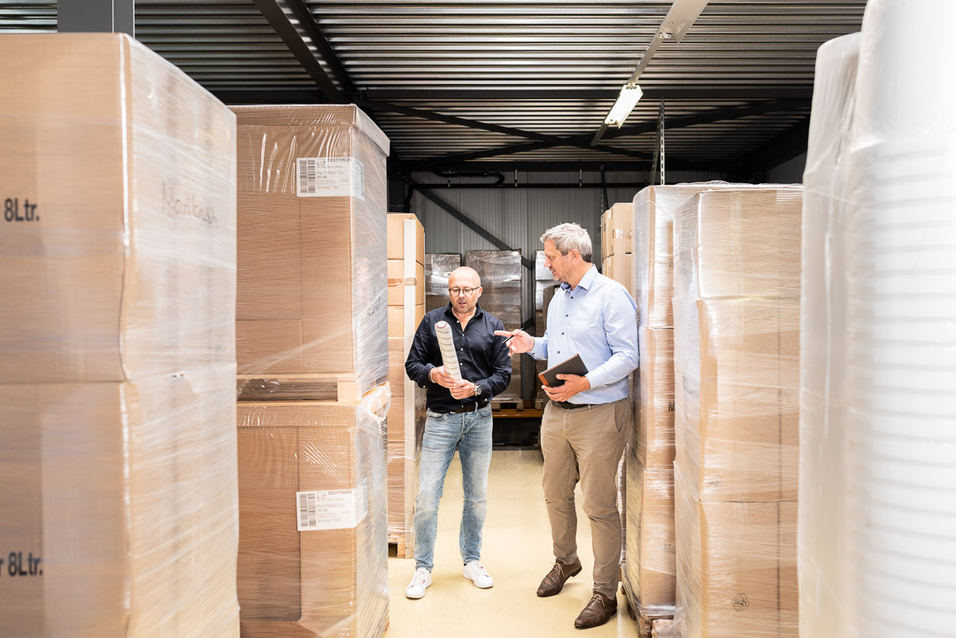 Twee collega's in gesprek in een magazijn